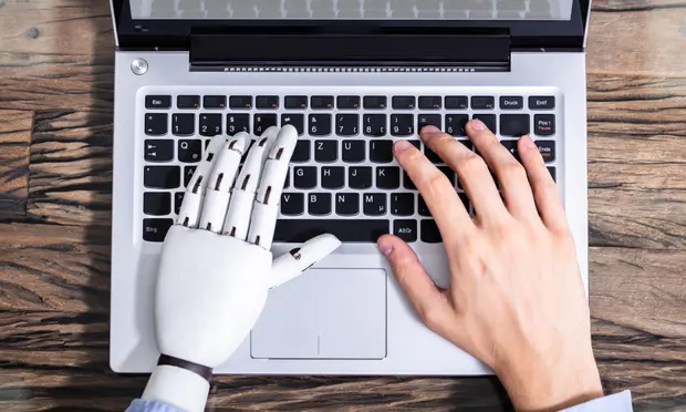 Robot and human hands typing on a keyboard